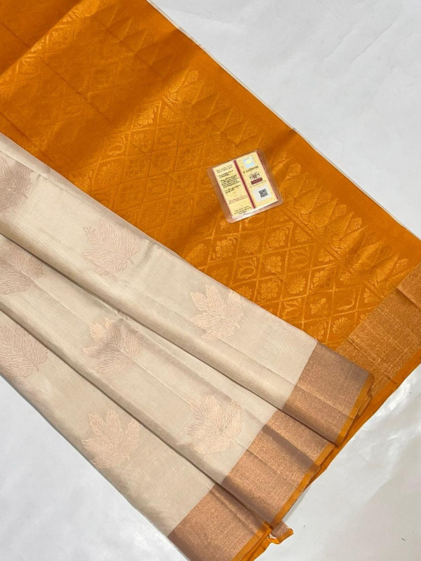 Pure Kanchipuram Saree in Pestal OffWhite colour along with Zari work Design in the full body of the saree with Dusty Orange Colour Pallu with Golden Zari Border